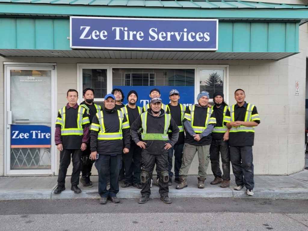 Zee Tire Services team in front of the shop